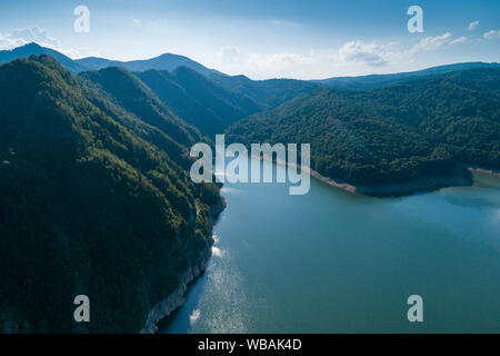 Antenna vista superiore su una montagna Fagaras Vidraru circostante diga con un serbatoio Lago, costruito sul fiume di Arges e si trova su una strada Transfagarasan, Foto Stock
