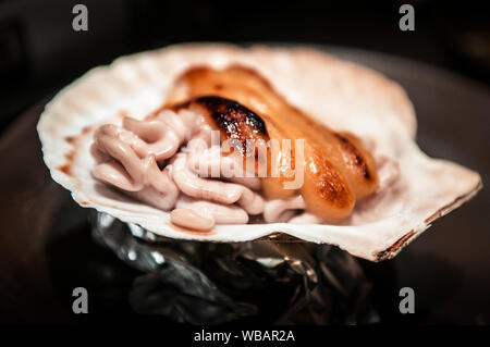 Yaki giapponese formaggio Shirako sulla shell, Giapponese grigliate di pesce lo sperma sac con formaggio, cucina di Aomori Foto Stock