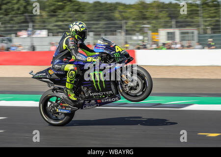 Silverstone, UK. Il 24 giugno 2019. Il pilota della MotoGP Valentino Rossi (Monster Energy Yamaha MotoGP) tira una impennata dopo le qualifiche al 2019 GoPro British Grand Prix (MotoGP) sul circuito di Silverstone, Towcester, in Inghilterra il 24 agosto 2019. Foto di David avvisatore acustico. Credito: prime immagini multimediali/Alamy Live News Foto Stock