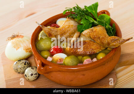 Di spessore e solyanka piccante con quaglie, prosciutto, olive, uova e cetrioli sottaceto servita con verdi in vaso di creta Foto Stock