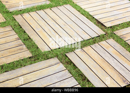 Pavimento in legno ,all'aperto sullo sfondo, piccoli blocchi rettangolari di legno e striscia di erba. Foto Stock