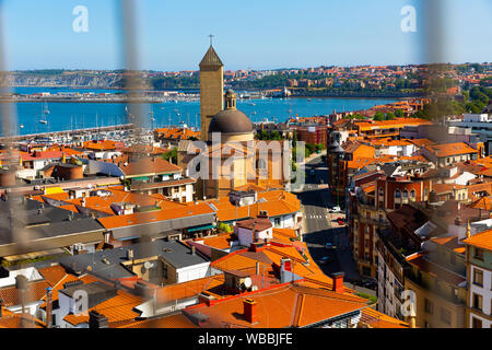 Vista dal Ponte di Vizcaya di Getxo cityscape sulla banca del fiume Nervion Affacciato sulla chiesa di Nostra Signora della Misericordia, Paesi Baschi Foto Stock