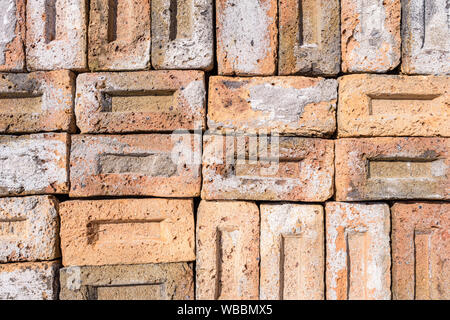 Una raccolta di materiali riciclati vecchi mattoni. I mattoni sono puliti da malta e calcestruzzo e pronto per il riutilizzo. Foto Stock