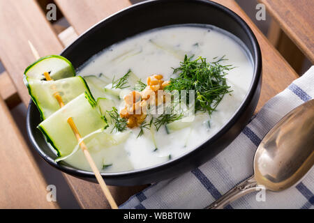 Cucina Bulgara. Tradizionale zuppa refrigerate Tarator su yogurt con Fresco cetriolo, aneto e noci in lamiera nera Foto Stock