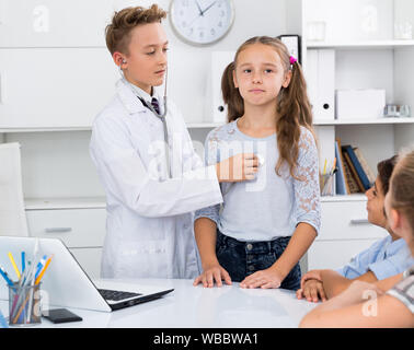 Giovane maschio medico in uniforme medica leader appuntamento con i bambini Foto Stock