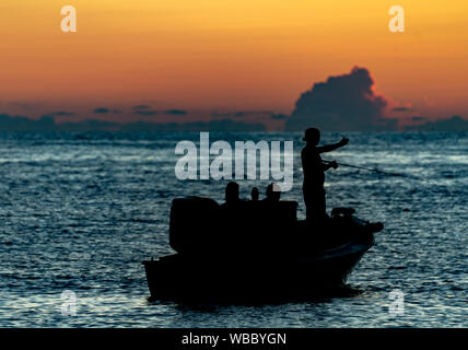 Silhouette di pescatori sul Golfo del Messico al tramonto Foto Stock