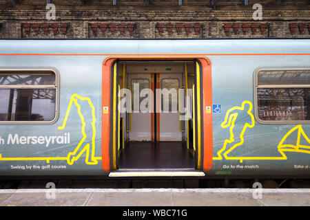 Aprire le porte su un treno di Merseyrail durante la sosta in corrispondenza di una stazione Foto Stock