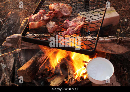 Cuocere carne e uova bollente sul fuoco Foto Stock