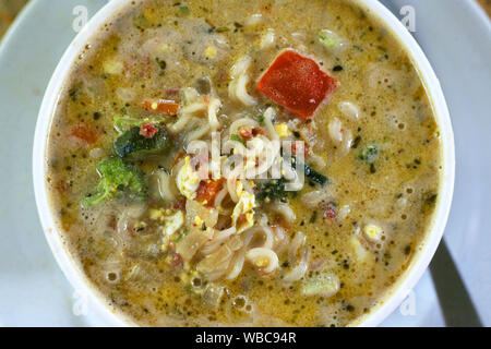 Ramen zuppa in vaso bianco con formaggio e ketchup Foto Stock