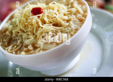 Ramen zuppa in vaso bianco con formaggio e ketchup Foto Stock