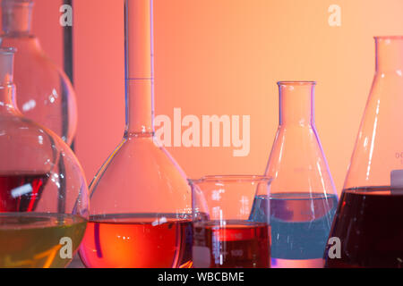 Laboratorio retroilluminato del pallone di prova contenenti liquidi colorati. Foto Stock