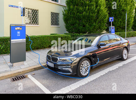 BMW 5 Series ibrido plug-in in corrispondenza di una stazione di carica a Monaco di Baviera, Germania Foto Stock