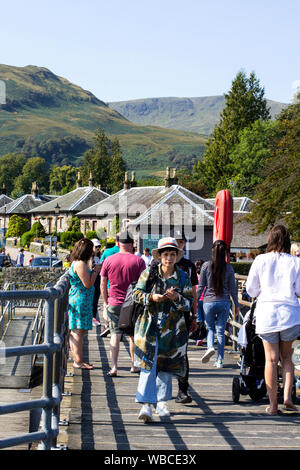 Luss, Argyll & Bute, Scozia, Agosto 25, 2019: centinaia di persone visitano un piccolo e pittoresco villaggio sulla sponda occidentale del Loch Lomond per prendere il sole e Foto Stock