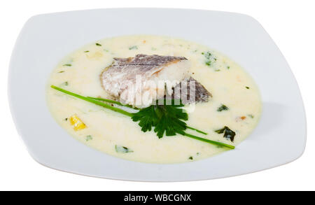 Una deliziosa minestra con eglefino affumicato, patate e cipolle servito con verdi in vaso bianco - piatto tradizionale della cucina scozzese. Isolato su bianco Foto Stock