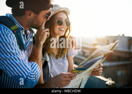 Felice coppia giovane di viaggiatori tenendo la mappa in mani Foto Stock