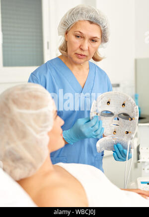 Conduzione di ringiovanimento facciale procedura medica utilizzando una maschera con elettrodi Foto Stock