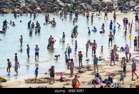 Lyme Regis, Dorset, Regno Unito. 26 Ago, 2019. Meteo REGNO UNITO: folle di beachgoers gregge al mare del resort di Lyme Regis a crogiolarvi al sole un altro giorno di caldo torrido sole e registrare la rottura tenperatures. La spiaggia è ricca di nuovo come il vertiginoso aumento delle temperature sono impostati per rendere questo più calde di ferragosto poiché i record ha iniziato a. Credito: Celia McMahon/Alamy Live News Foto Stock