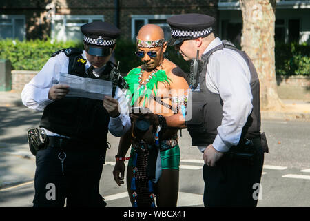 A Notting Hill, Londra, Regno Unito. Il 26 agosto 2019. Un attore è assistita da Policy Officer presso l annuale carnevale di Notting Hill parade . Più di 2 milioni di persone sono attese a frequentare l'Europa il più grande partito di strada su due giornate del weekend festivo Credito: amer ghazzal/Alamy Live News Foto Stock