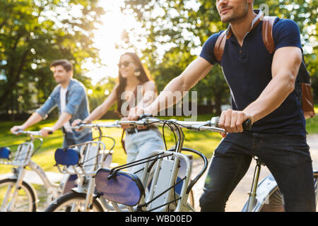 Immagine ritagliata di un gruppo di felice allegro amici equitazione biciclette presso il parco Foto Stock