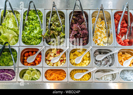 Vista superiore del salad bar con vari tipi di frutta e verdura compresi lattuga, pomodoro, mais, uovo, anguria, carota, cetriolo, e molto di più Foto Stock