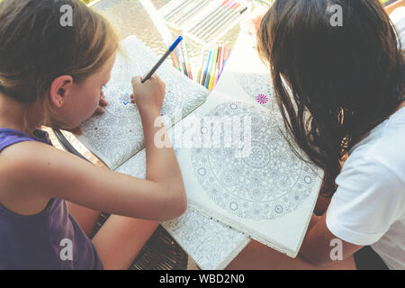 Bambine dipingere un libro da colorare Foto Stock