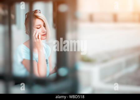 Giovane donna bionda parlando al telefono Foto Stock