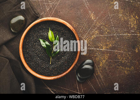 Close up di nero Semi di sesamo, Sesamum indicum nella ciotola di legno Foto Stock