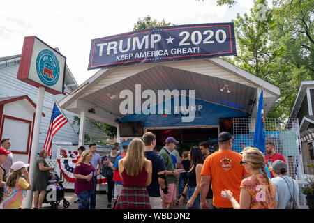 Falcon Heights, MN - Agosto 25, 2019: Fairgoers si raccolgono intorno al Trump Pence MN GOP stand del fornitore a sostegno del presidente Donald trionfi 2020 ri-electi Foto Stock