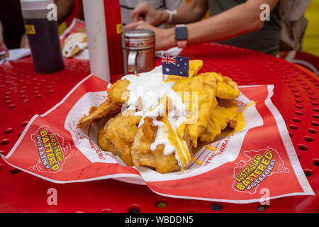 Falcon Heights, MN - Agosto 25, 2019: una piastra di Austrailian martoriata patate su un tavolo presso la Minnesota State Fair. La frittura è coperto in ch Foto Stock
