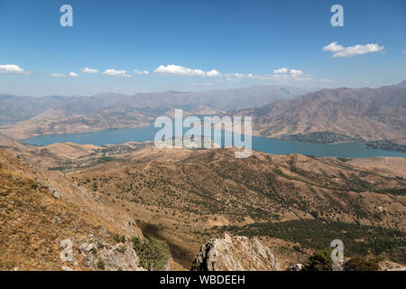 Una vista guardando verso il lago di Charvak dal Chatkal montagne in Ugam-Chatkal Parco Nazionale in Uzbekistan. Foto Stock