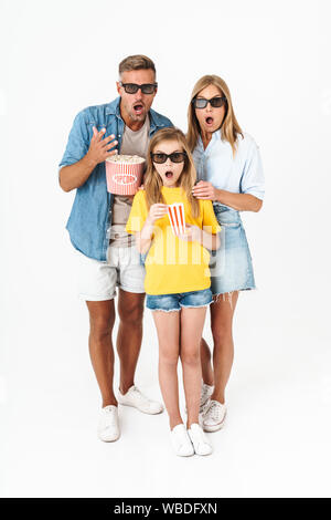 Foto di famiglia sorpreso in occhiali 3D azienda benna popcorn durante la visione di un filmato in cinema isolate su sfondo bianco Foto Stock