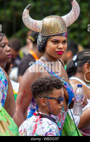 Una donna in un viking hat, con un giovane ragazzo, durante la celebrazione.I principali eventi del carnevale di Notting Hill 2019 ha preso il via con oltre un milione di festaioli di colpire le strade di West London, tra i galleggianti, masqueraders, nastri di acciaio, e sistemi audio. Foto Stock