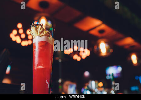 Rosa e Rosso colorato fresco esotici cocktail alcolico con limone e ghiaccio nel bar. Colorato di rosa soft drink con ghiaccio sulla barra desk. Colorate di rosso M Foto Stock