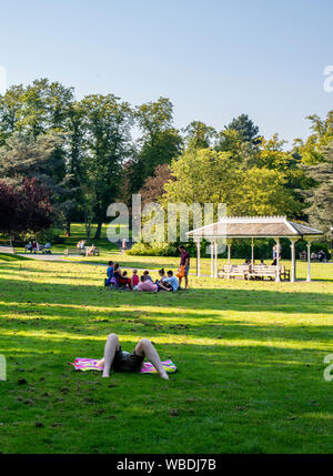 Persone relax su erba nel parco sul tempo molto caldo, lunedì festivo, Valley Gardens, Harrogate, Regno Unito, 26 agosto 2019 Foto Stock