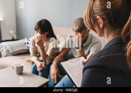 Foto di soggetti di razza caucasica infelice giovane uomo e donna che piange e una conversazione con lo psicologo sulla sessione di terapia in camera Foto Stock