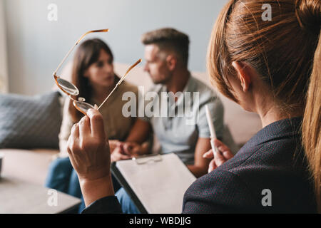 Foto di pensare caucasian giovane uomo e donna una conversazione con lo psicologo sulla sessione di terapia in camera Foto Stock