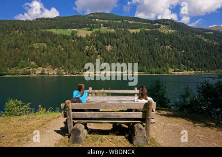 Due donne di riposo e relax di fronte al Lago di Zoccolo (Zoggler Stausee), Val d'Ultimo (Val d Ultimo), Bolzano, Trentino Alto Adige, Italia Foto Stock