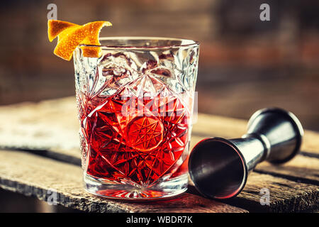 Cocktail Negroni su una vecchia tavola di legno. Bere con gin, campari martini rosso e arancione Foto Stock