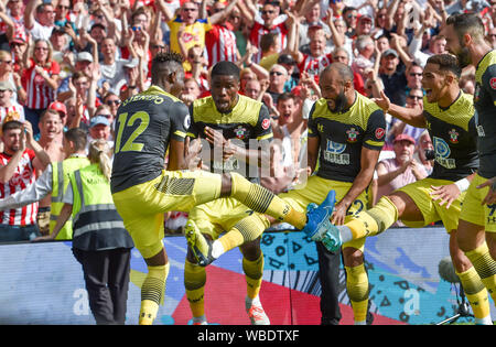 Moussa Djenepo di Southampton (sinistra) viene assaliti dopo aver segnato il loro primo obiettivo durante il match di Premier League tra Brighton e Hove Albion e Southampton presso la American Express Community Stadium , Brighton , 24 agosto 2019 solo uso editoriale. No merchandising. Per le immagini di calcio FA e Premier League restrizioni si applicano inc. no internet/utilizzo mobile senza licenza FAPL - per i dettagli contatti Football Dataco Foto Stock