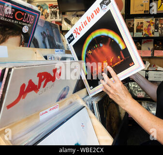 Donna che guarda la LP in vinile in record store, negozio nel mercato Grainger a Newcastle upon Tyne. Regno Unito Foto Stock