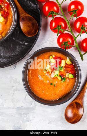 Tradizionale a freddo gazpacho minestra di pomodoro in un campo di bocce nero su sfondo grigio. Foto Stock