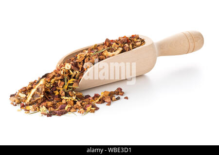 Cumulo di frutta secca di infusione del tè con arance e fragole miscelato con foglie di tè e un assortimento di erbe nel convogliatore di legno su sfondo bianco Foto Stock