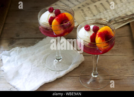 Gelato di pesche e salsa di lamponi dessert dedicata alla Australian cantante lirica Melba. Stile rustico. Foto Stock