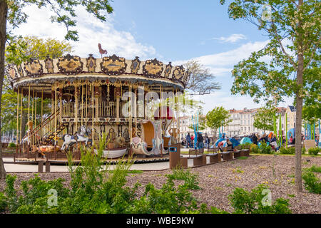 La Rochelle, Francia - 08 Maggio, 2019: un popolo sono in appoggio vicino al merry-go-round nel Parco Divertimenti su una piazza di La Rochelle, Francia Foto Stock