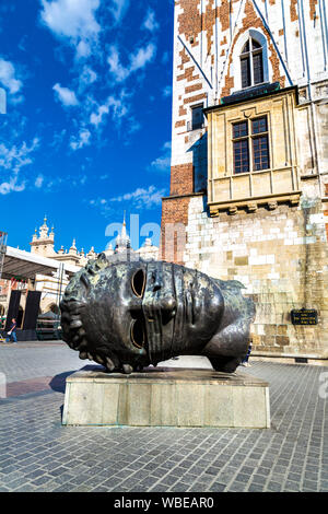 "L'Eros Bendato' scultura di una testa sulla piazza principale (Rynek Glowny) dall'artista polacco Igor Mitoraj, Cracovia in Polonia Foto Stock