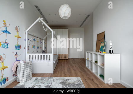 Mensole con libri e decorazioni appese su pareti chiare Foto stock - Alamy