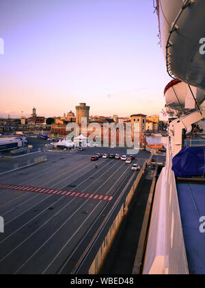 Vista del porto di Livorno al tramonto da un traghetto ormeggiata presso il molo. Foto Stock