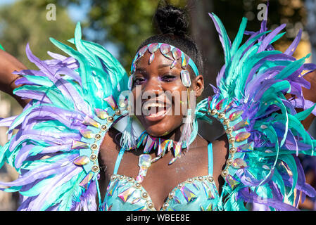 Femmina nel coloratissimo elaborato costume giamaicano al carnevale di Notting Hill parata finale su un caldo lunedì festivo Foto Stock