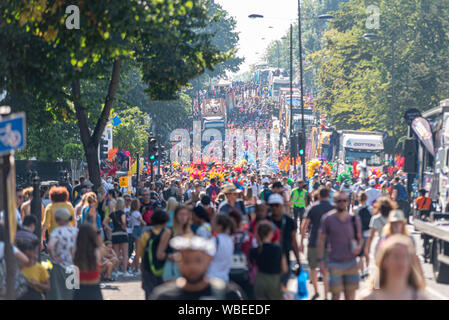 Grande raduno dei partecipanti al carnevale di Notting Hill parata finale su un caldo lunedì festivo. Una folla di persone Foto Stock