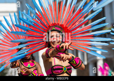 Femmina nel coloratissimo elaborato costume giamaicano al carnevale di Notting Hill parata finale su un caldo lunedì festivo Foto Stock